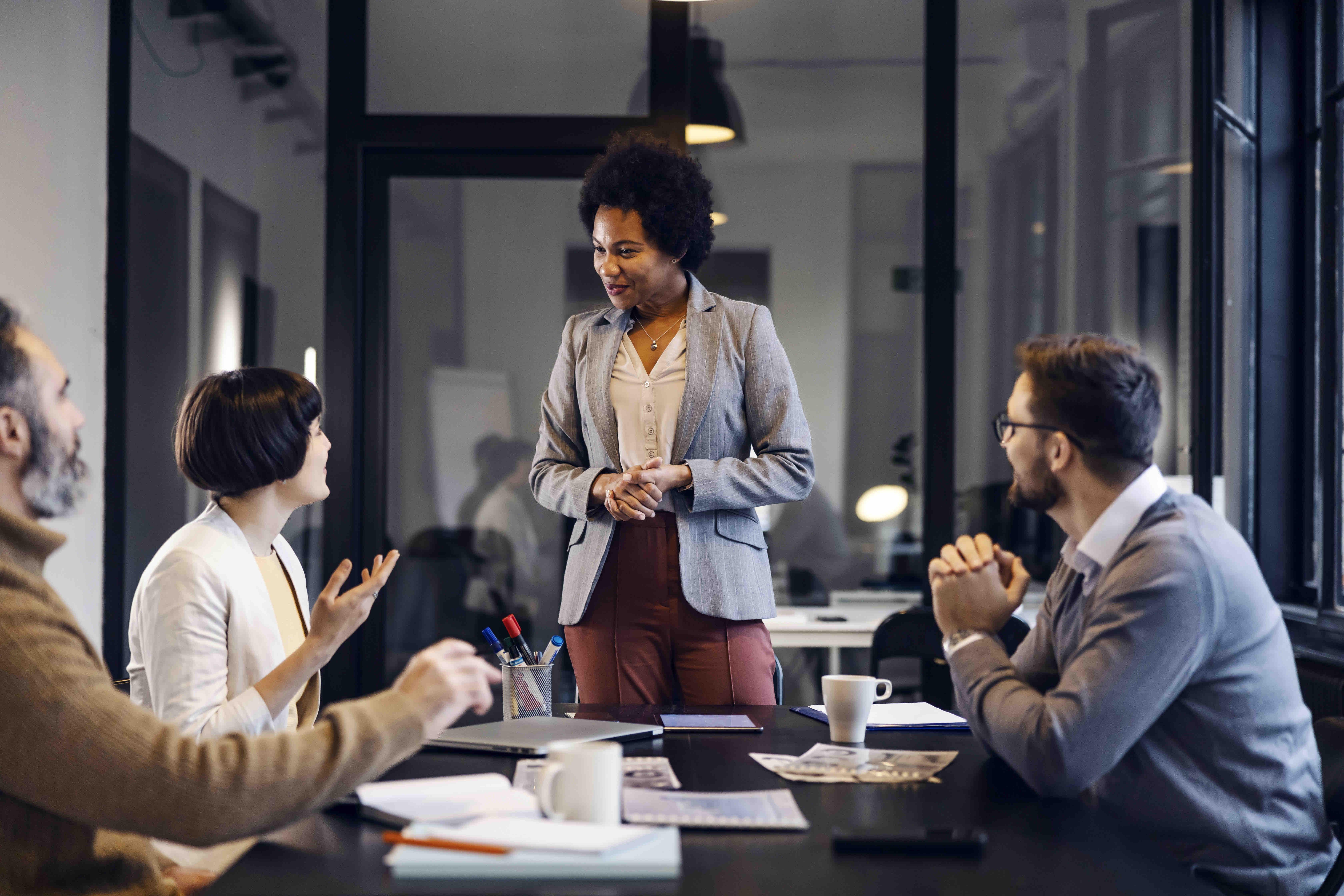 Multiracial female team leader having business meeting with employees